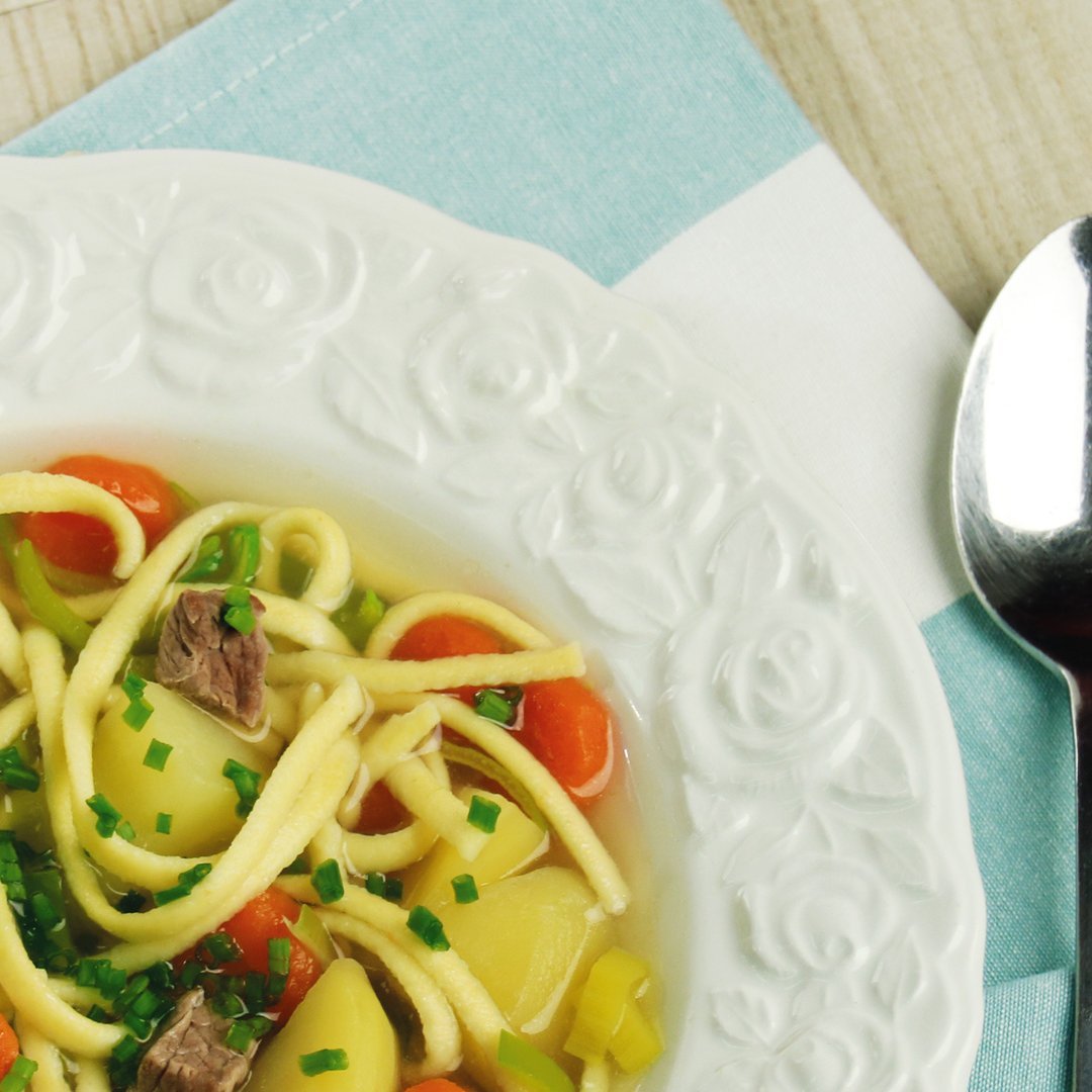 Bowl of Gaisburger Marsch, a traditional German stew with noodles, vegetables, and meat in broth