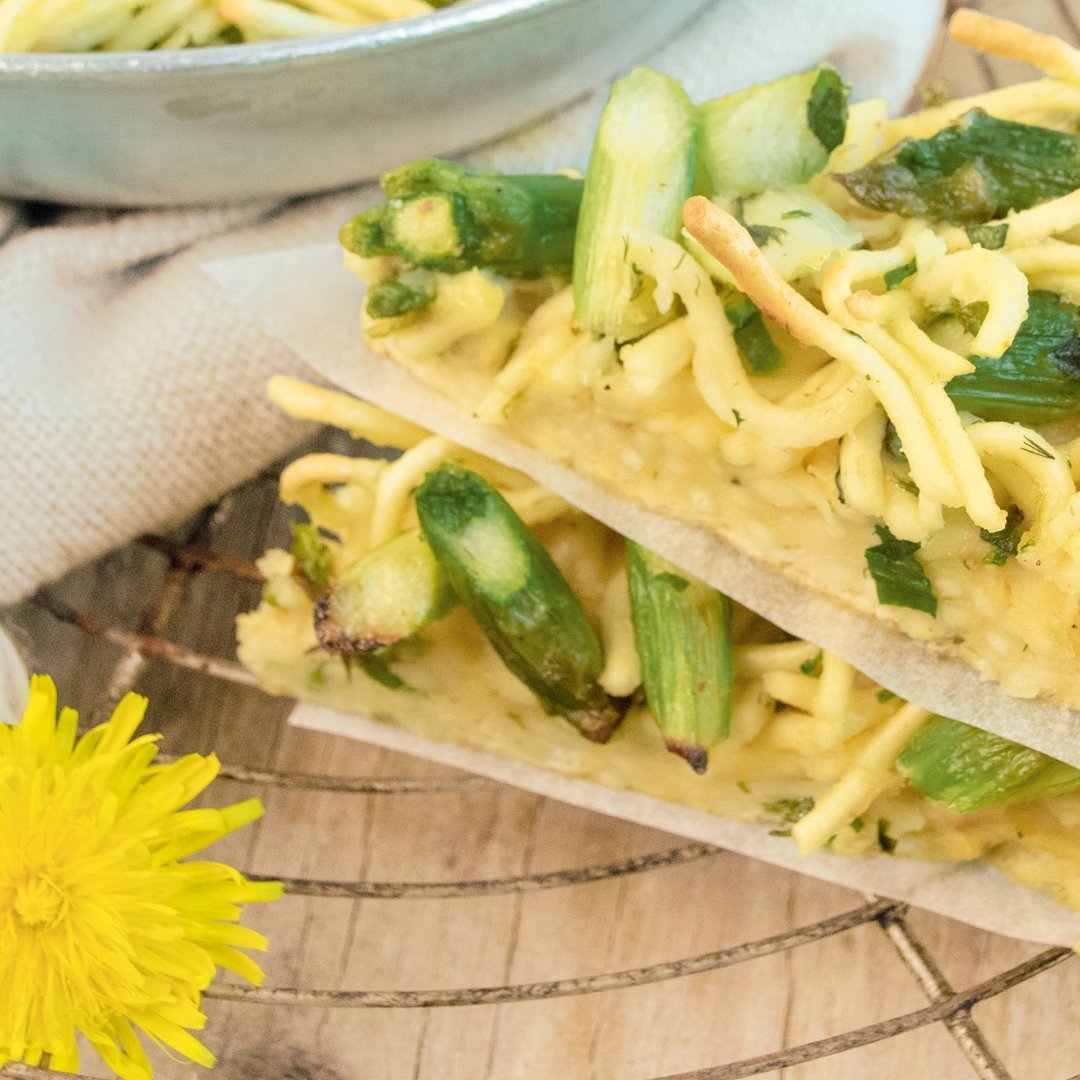 Close-up of a Spaetzle-Asparagus-Frittata showing golden spaetzle noodles and green asparagus pieces layered in a glass dish